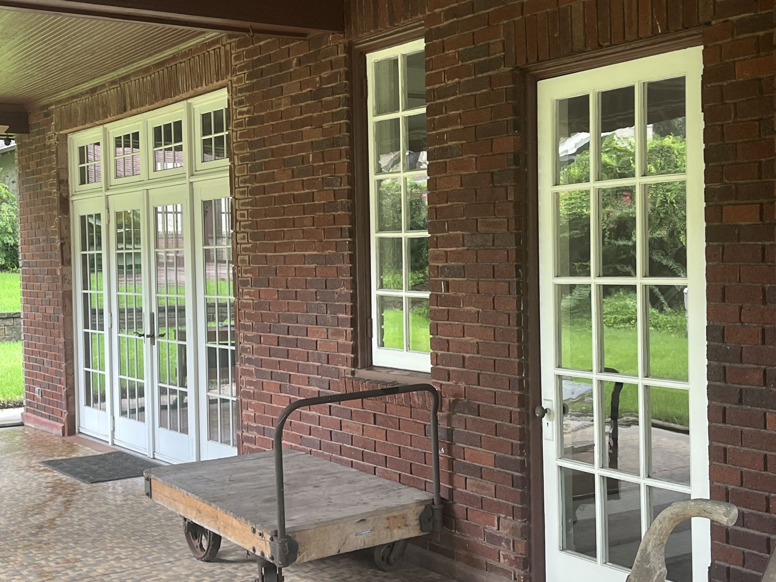 Clean French doors and windows along a brick porch
