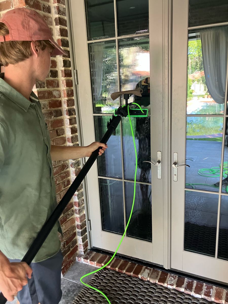 Cleaning French doors with a water-fed pole
