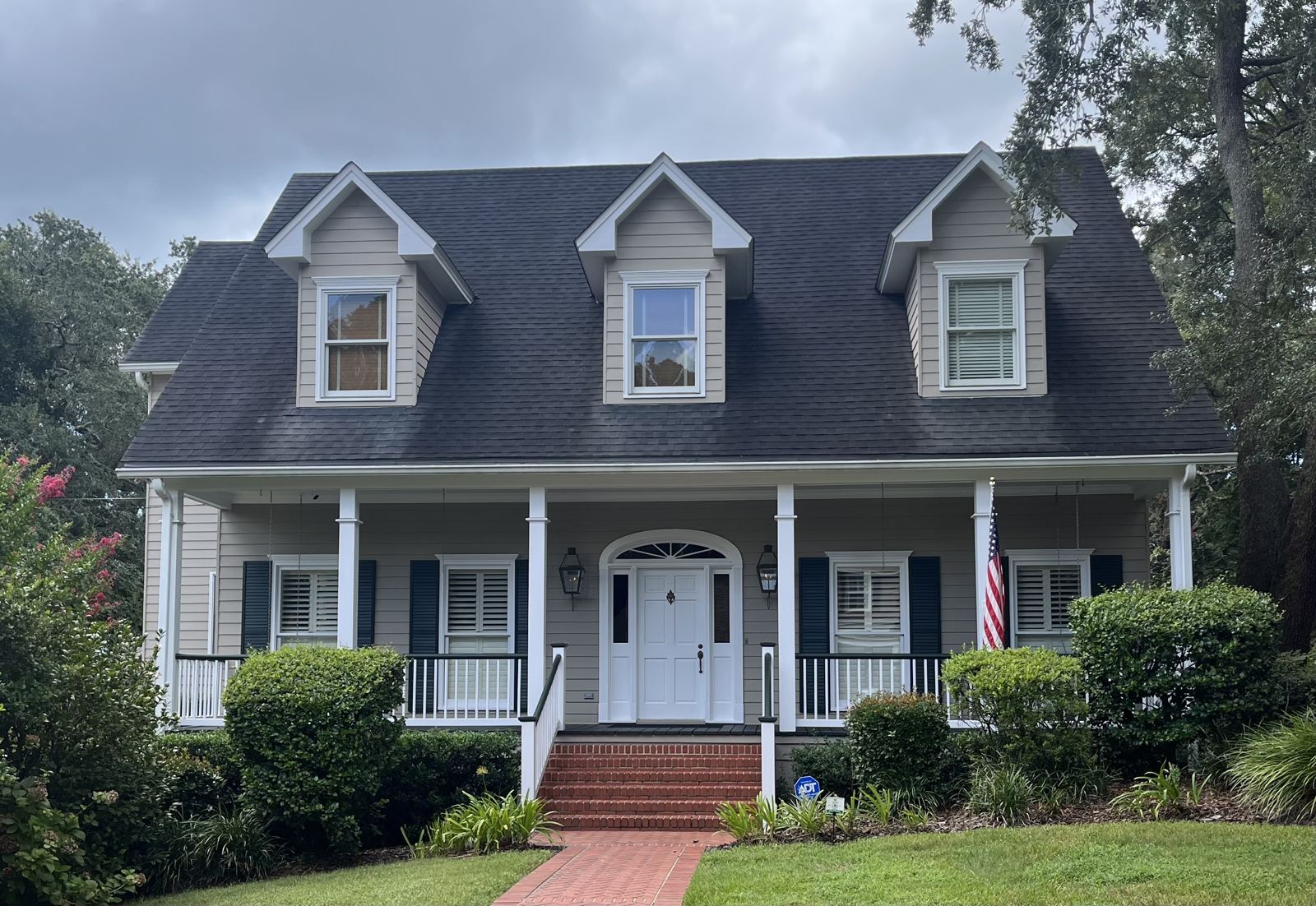 Front of a two-story home with sparkling dormer and porch windows
