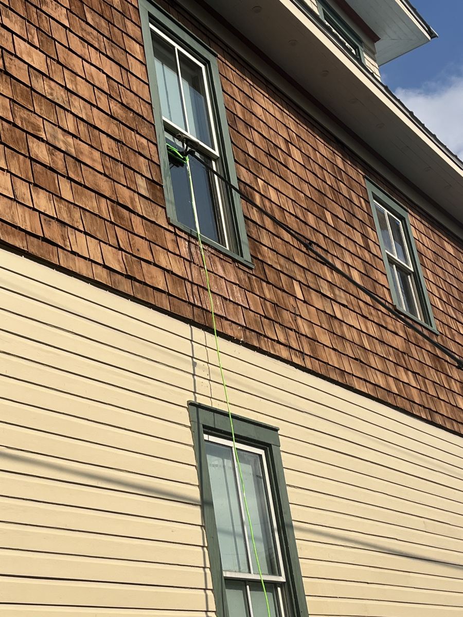 Cleaning second-story windows with a water-fed pole